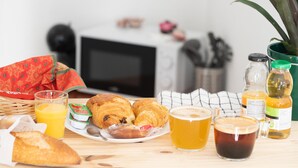 Uma mesa de café da manhã com croissants, suco, café e uma garrafa de suco.