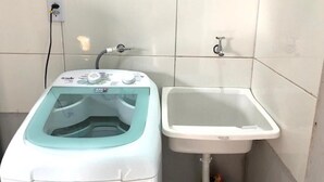 Ein Badezimmer mit Waschmaschine und Waschbecken.