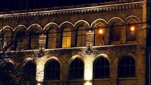 A historic building with arched windows and a storefront displaying clothing. - Cozy 1BD w/ View in Walker's Point, Free Parking (Milwaukee)