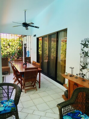 Relax in this serene outdoor space with a large dining table and comfortable seating.