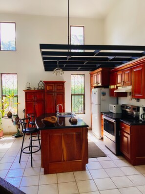 Enjoy cooking in this well-equipped kitchen with a central island, sink, and stove.