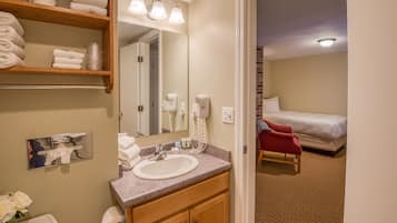 A hotel bathroom with a sink, mirror, towel rack, and toiletries.
