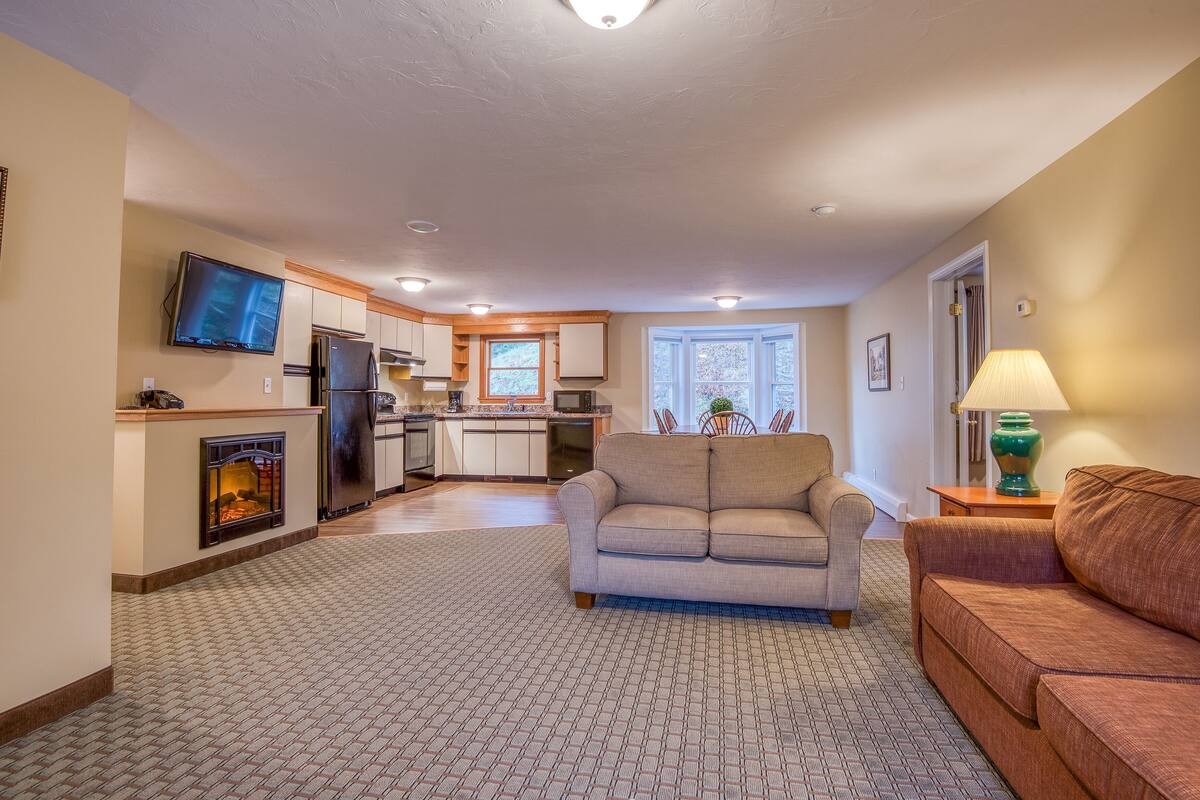 A living room with a fireplace, a sofa, and a television.