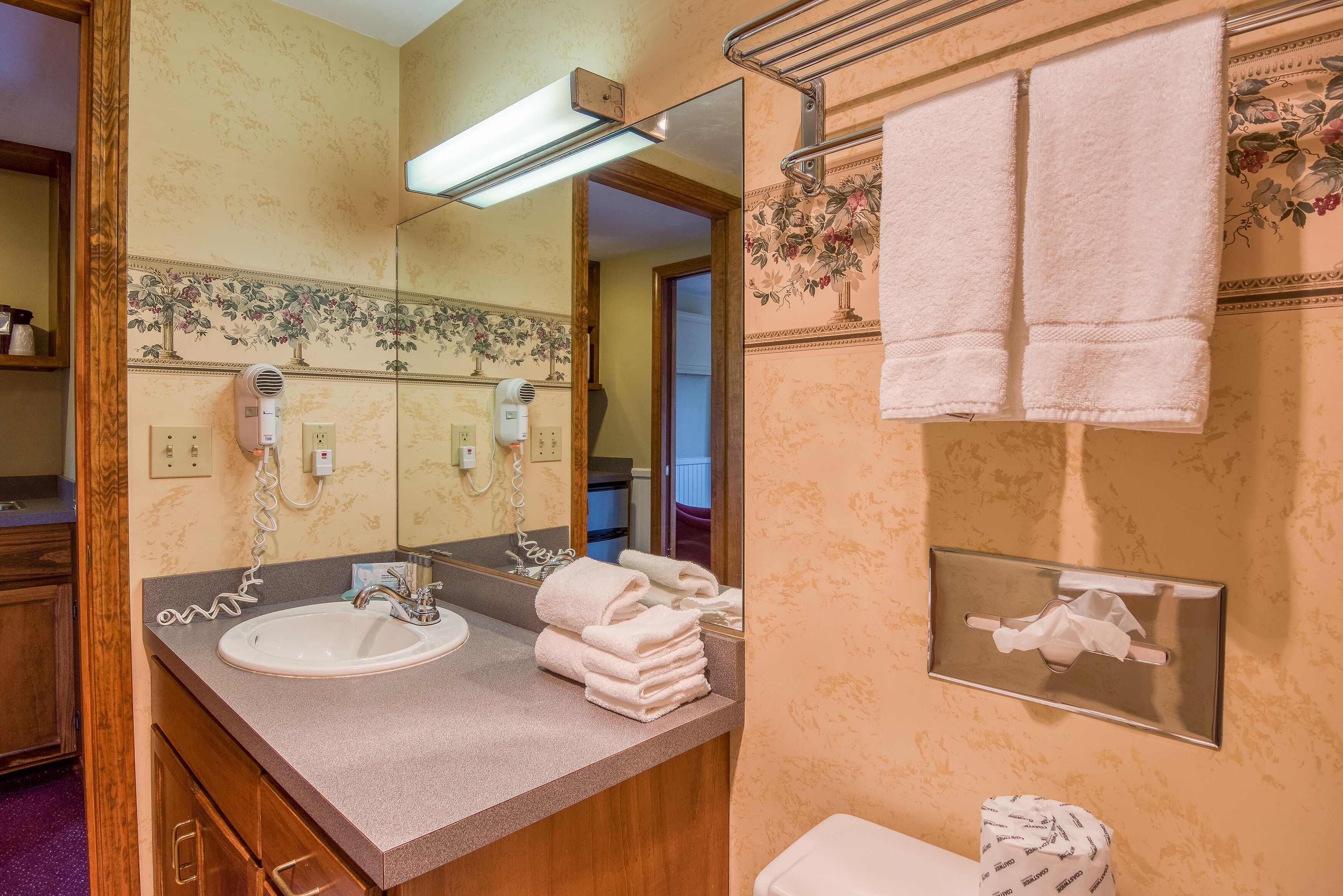 A bathroom with a sink, towel rack, and a mirror.