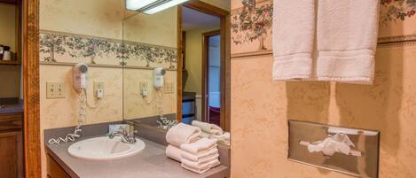 A bathroom with a sink, towel rack, and a mirror.