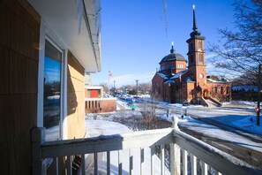 Guests can enjoy a balcony with a railing overlooking a historic church in the background.