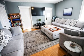 Relax in this stylish living room with a sofa, ottoman, and flat-screen TV.