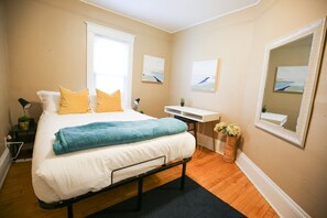 Relax in a serene bedroom with a made bed, bedside table, and comfortable seating area.