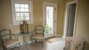 Une pièce avec deux chaises, une petite table, une porte et un placard.