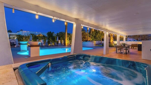 A hot tub area with a pool, outdoor seating, and a view of the surrounding landscape. - Luxury Desert Oasis+Sport Court+Theater+Golf+ Spa (Scottsdale)