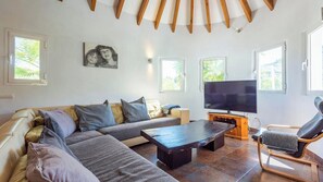 A modern living room with a sectional sofa, a coffee table, a TV, and a recliner. - Casa Holly Comares by Ruralidays (Málaga)