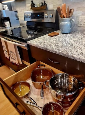 Una cocina con encimera de granito, electrodomésticos de acero inoxidable y armarios de madera.