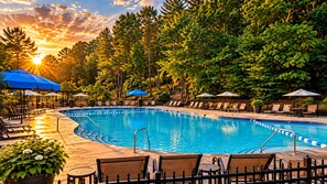 A swimming pool with lounge chairs and umbrellas, surrounded by trees. - Romantic Retreat in the Treetops of Big Canoe with Hot Tub & Stunning Views! (Jasper)