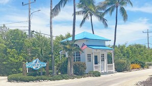 Een klein wit gebouw met een blauw dak en een Amerikaanse vlag, aangeduid als 'Ocean Pointe'.