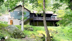 A cabin with a wooden exterior, a balcony, and a staircase leading to an upper level. - Rock Hill Retreat- a home with natural stone formations at every turn!  (Rockbridge)