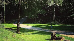 A sign for Rock Hill Retreat with a scenic view of a grassy area, trees, and a stream. - Rock Hill Retreat- a home with natural stone formations at every turn!  (Rockbridge)