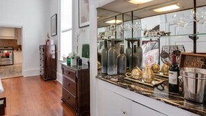 A kitchen with a marble countertop, wine glasses, bottles, and a 'Uncork' sign. - Downtown Memphis 2 BR Eleanor Rigby suite Apt 101 (Memphis)