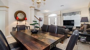 A dining area with a wooden table, chairs, and a bonsai tree centerpiece. - Exclusive 5 Star Villa with Private Pool on Windsor Palms Resort, Orlando Villa 4902 (Orlando)