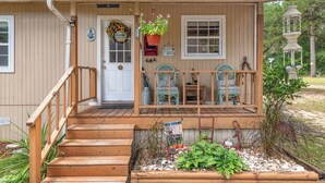 A wooden house with a porch, a door with a wreath, and a hanging flower pot. - FAMILY FOREST RETREAT, PARADISE AT POINT PLEASANT (Salt Springs)