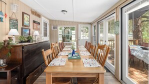 A dining area with a wooden table, chairs, and a counter with a menu board. - FAMILY FOREST RETREAT, PARADISE AT POINT PLEASANT (Salt Springs)