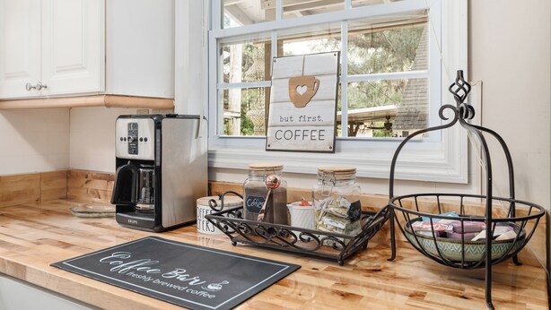 A kitchen with a coffee maker, jars of coffee, and a sign that says "but first, COFFEE". - FAMILY FOREST RETREAT, PARADISE AT POINT PLEASANT (Salt Springs)