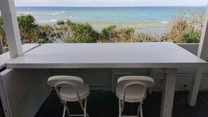 A white table with two white chairs on a balcony overlooking the ocean. - Maribu Beach House (Onna)