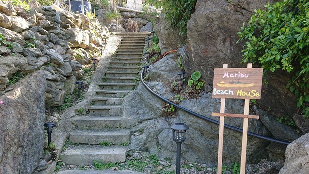 A stone staircase leading to a wooden sign that reads "Maribu Beach House". - Maribu Beach House (Onna)