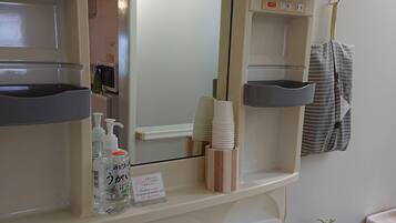 A bathroom with a sink, mirror, and various toiletries.