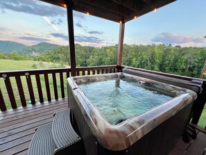 A hot tub on a wooden deck with a view of a forested landscape. - Kids Mini Cabin Bunk Room- Sleeps 12, Hot Tub, Views, Pool Table = Core Memories (Sevierville)