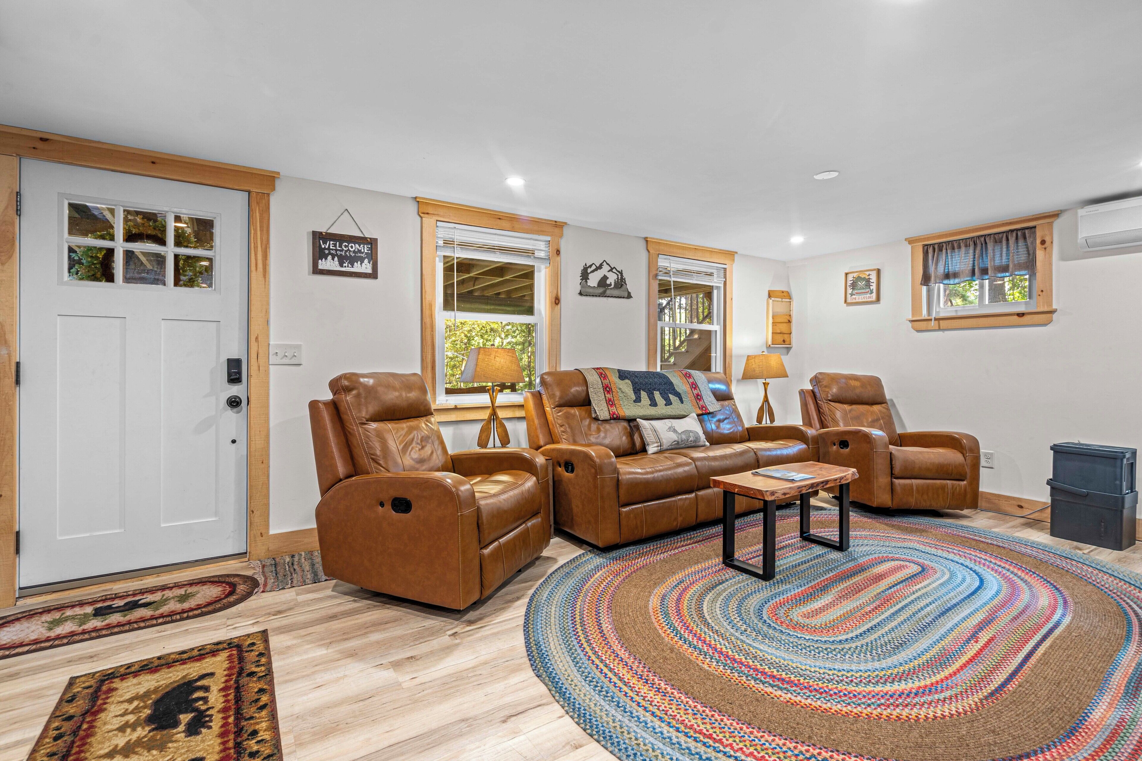 A living room with leather sofas, a coffee table, and a patterned rug.