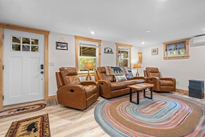 Ein Wohnzimmer mit Ledersofas, einem Couchtisch und einem gemusterten Teppich.