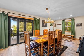 A dining area with a wooden table, chairs, and a chandelier.