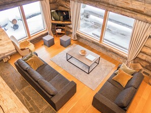 A cozy living room with a sofa set, a coffee table, and a television.