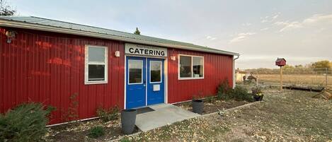 A red building with a blue door labeled "CATERING" and a small window.