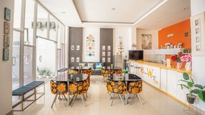 Un vestíbulo de hotel moderno con una recepción, una zona de estar y grandes ventanales.