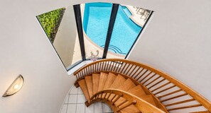 A wooden staircase with a view of a swimming pool and outdoor seating area. - Just steps to the beach, sleeps 16, Golf cart, Dolphin Beach House huge pool! (Fort Lauderdale)