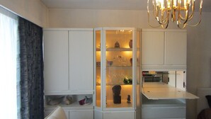 Una cucina moderna con mobili bianchi, una cantinetta per vini a scomparsa e un lampadario.