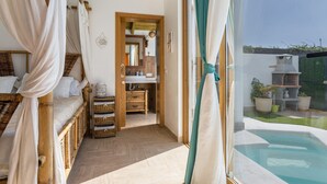 Une chambre avec un lit, une coiffeuse, un miroir et une vue sur une piscine extérieure.