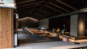 A spacious indoor area with a long wooden table, several chairs, a sofa, and a small green table. - Sono Pet Clubs & Resorts VivaldiPark (Hongcheon)