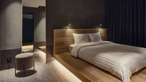 A modern bedroom with a large bed, a round ottoman, a mirror, and a dark curtain. - Sono Pet Clubs & Resorts VivaldiPark (Hongcheon)