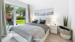 Una camera da letto moderna con un letto grande, un comodino e vista sull'esterno.