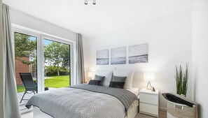 Un dormitorio moderno con una cama grande, una mesita de noche y vistas al exterior.