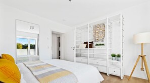 Relax in this serene bedroom with a large bed and wardrobe.