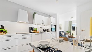 Enjoy a spacious open-plan kitchen with a central island and dining area for four, featuring a sofa and coffee table.