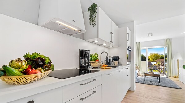 Enjoy meals in this kitchen with a view, featuring a cooktop, coffee maker, and ample counter space.