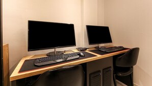 A dual-monitor workstation with two keyboards and mice, a wooden desk, and a black office chair. - Busan Seomyeon Business Hotel J7 (Busan)