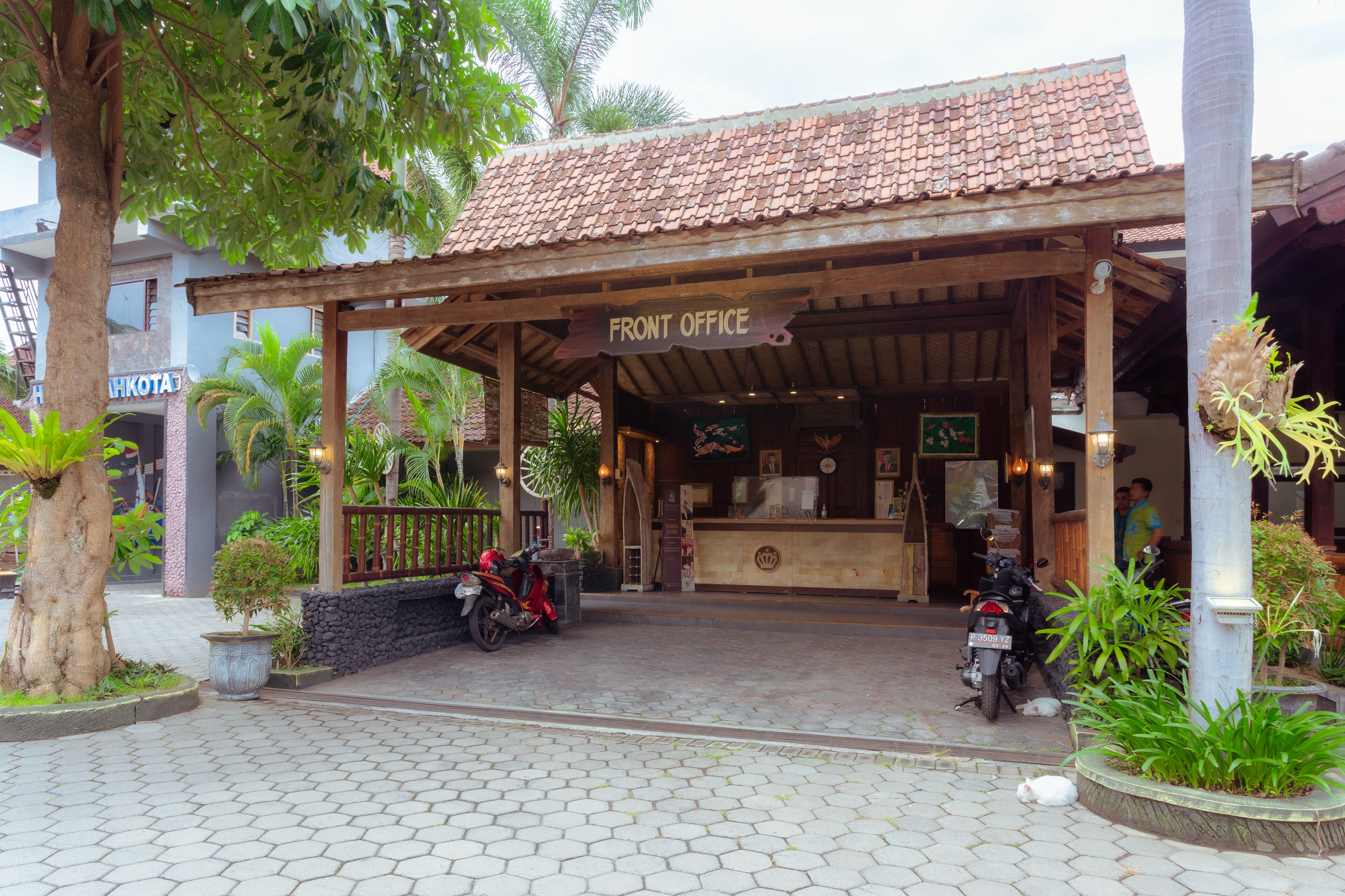 A front office area with a tiled roof, a sign reading "FRONT OFFICE," and two motorcycles parked outside.