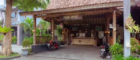 A front office area with a tiled roof, a sign reading "FRONT OFFICE," and two motorcycles parked outside.