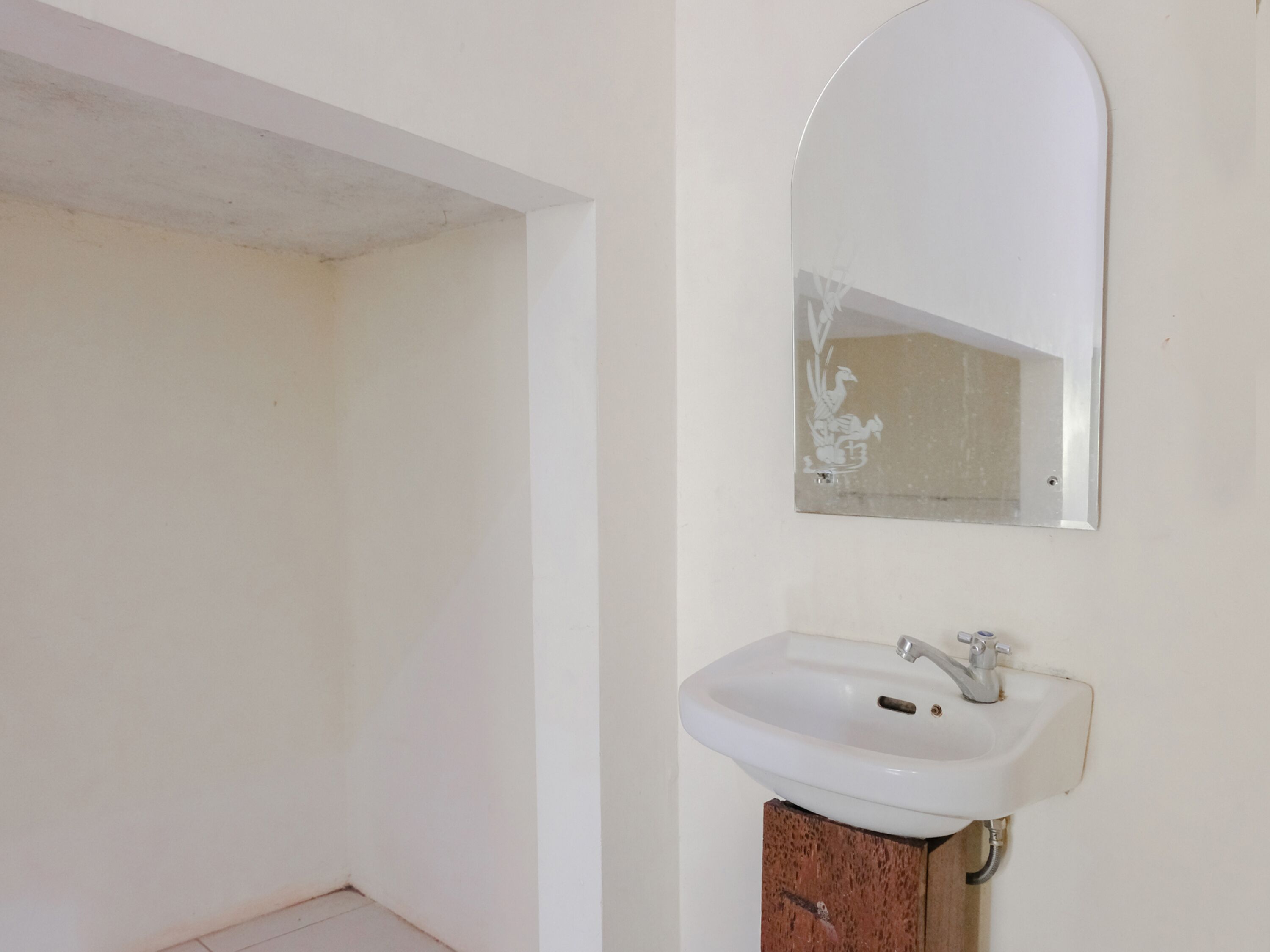 A bathroom with a white sink, a mirror, and a wooden cabinet.
