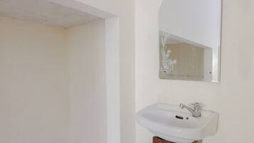 A bathroom with a white sink, a mirror, and a wooden cabinet.